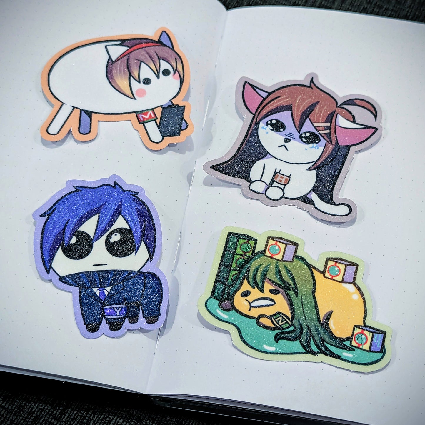 A set of glitter stickers of Malkuth, Hod, Yesod and Netzach from Lobotomy Corporation. Malkuth is baba from baba is you, Hod is in the meme of a crying cat, Yesod is the autism creature and netzach is the gudetama egg.